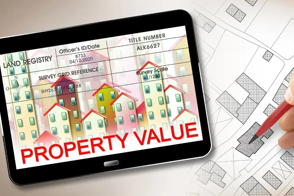 Top view of tablet showing graph of houses with “Property Value” on it, next to
hand marking on paper graph with pencil.