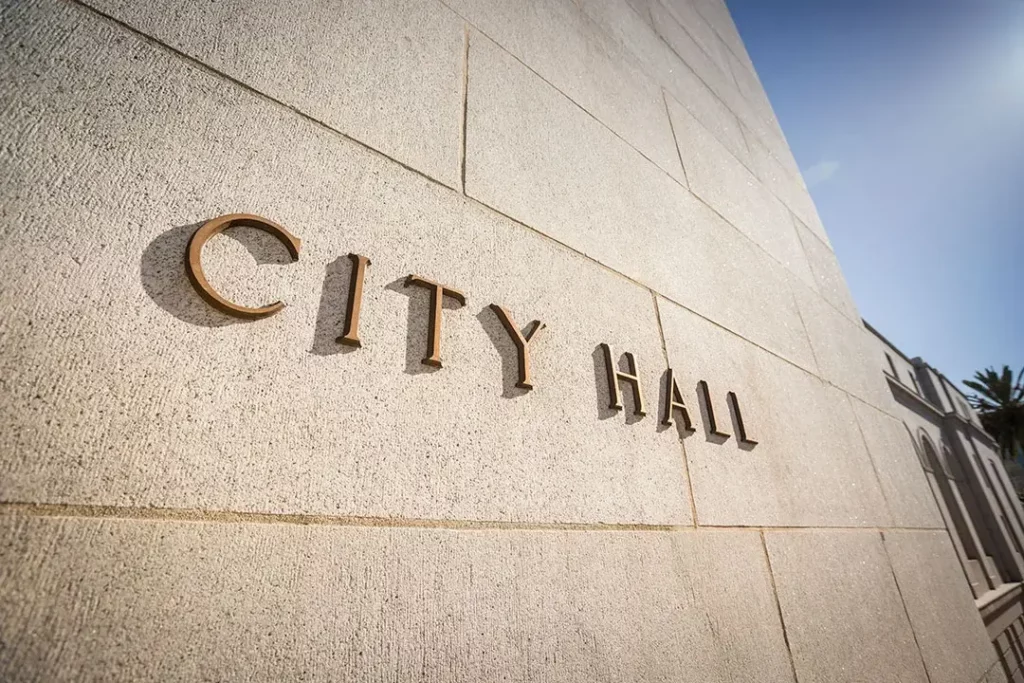 Side view of beige building with “City Hall” on the side.